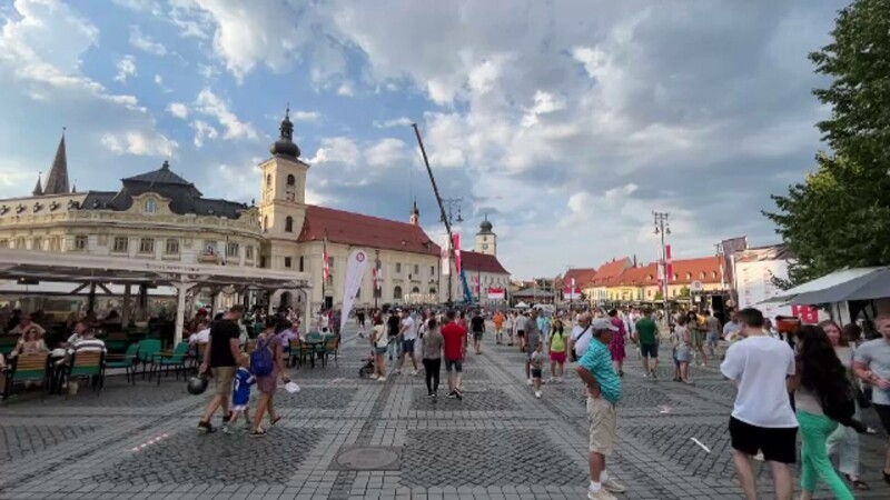 oameni pe strada, sibiu, piata mare, turisti